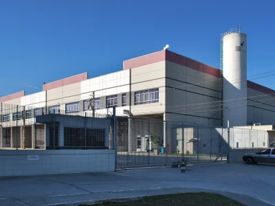 Vista em perspectiva de condomínio de galpões modulares ao fundo de céu azul.