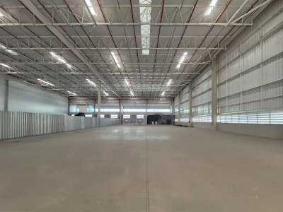 Vista geral do módulo de galpão. Ao fundo entrada de pedestres, portas com niveladoras para carga e descarga.