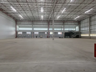 Vista geral do módulo de galpão. Ao fundo entrada de pedestres, portas com niveladoras para carga e descarga.